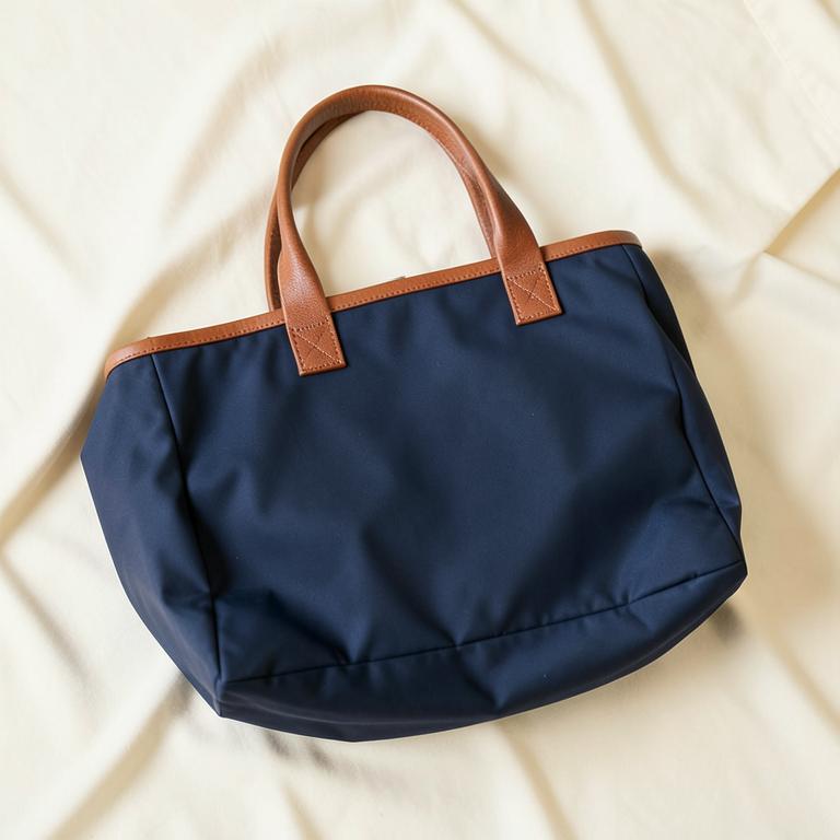 Navy nylon tote bag with brown leather handles